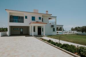 une grande maison blanche avec une allée. dans l'établissement Villa Despoina, à Paphos