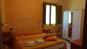 1 dormitorio con cama, ventana y espejo en La Casa dei Papaveri, en Lucca