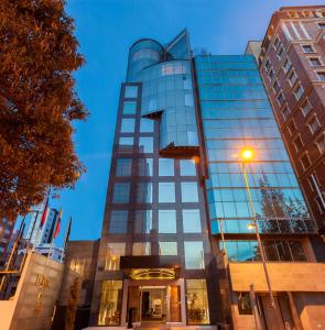 un edificio alto de cristal en una ciudad al atardecer en Le Parc Hotel, Beyond Stars en Quito