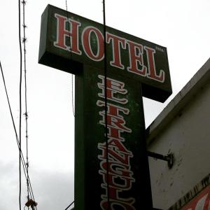a neon sign for a hotel on the side of a building at Hotel El Triangulo in Pitalito
