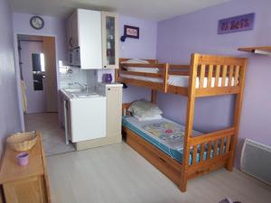 une petite chambre avec deux lits superposés et une cuisine dans l'établissement vostok G173, au Corbier