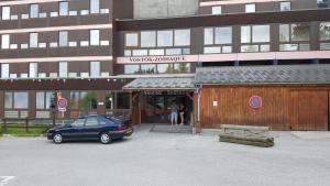 une voiture bleue garée devant un bâtiment dans l'établissement vostok G173, au Corbier