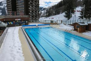 a large swimming pool with snow on the ground at vostok G173 in Le Corbier