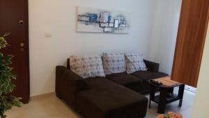 - un salon avec un canapé brun et une table dans l'établissement Apartments Bride's Rock, à Baška Voda