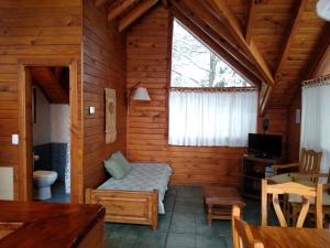 um quarto com uma cama num chalé de madeira em Calen-Hue em San Carlos de Bariloche