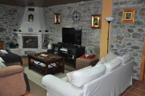 sala de estar con sofá blanco y chimenea en Casa Vilar de Friol, en Friol