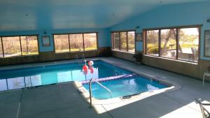 a large swimming pool in a building with windows at Oscoda Lakeside Hotel in Oscoda