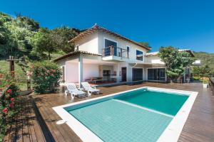 a villa with a swimming pool in front of a house at Casa Dos Sonhos in Búzios