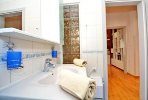 a white bathroom with a sink and a mirror at Apartments Andreja in Kožino +66 photos