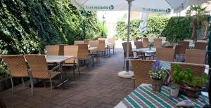 taras ze stołami, krzesłami i parasolem w obiekcie Hotel Restaurant Osterbauer w mieście Neunkirchen