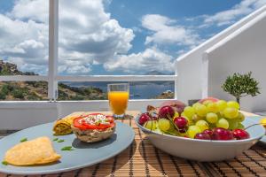 einen Tisch mit einer Schale Obst und einem Glas Orangensaft in der Unterkunft Halara Studios in Plaka Milos