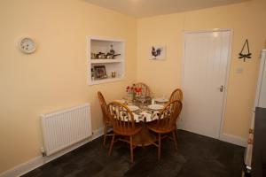 a dining room with a table and chairs at Maggie's Cottage in Kelso