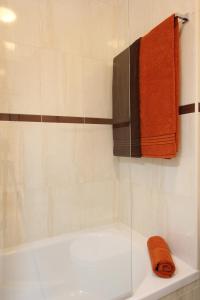 a bathroom with a bath tub with an orange towel at Skyline View in Lagos