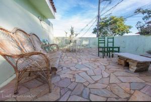 a patio with chairs and a bench and a table at Pousada Paraíso São thome in São Thomé das Letras