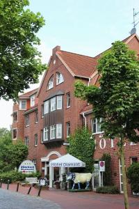 a large red brick building with a cow in front of it at Hotel Diamant in Wedel