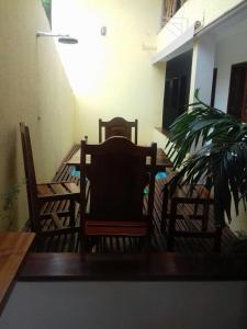 2 sillas, una mesa y una planta en el balcón en Pousada Quatro Irmãos, en Jericoacoara