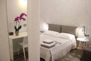 a bedroom with a bed and a table with purple flowers at Matera Guest House in Matera