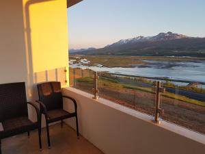 two chairs on a balcony with a view of a river at Hafdals Hotel in Akureyri