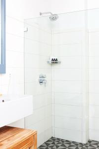 a bathroom with a shower with white tiles at Boro Hotel in Queens