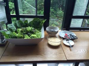 a bowl of greens sitting on a table with a window at Win D Hotel in Nakhon Ratchasima