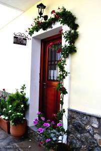 a red door with flowers on a white building at Filoxenia Studios in Galaxidhion