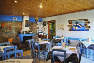 a restaurant with tables and chairs and a fireplace at Filoxenia Studios in Galaxidi