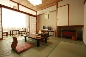 a living room with a table and a fireplace at Musashibou in Hiraizumi