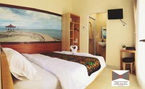 a bedroom with a bed with a painting of a beach at The Alley City Hotel in Sanur