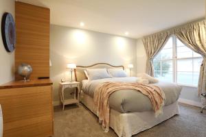 a bedroom with a large bed and a window at The Lodges At Transport World in Invercargill