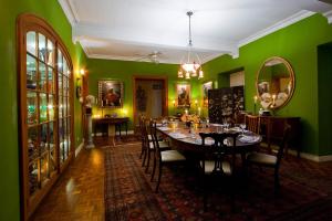 a dining room with a table and green walls at Colleton Great House in Saint Peter