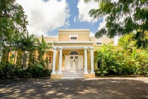 a large yellow house with a white door at Colleton Great House in Saint Peter