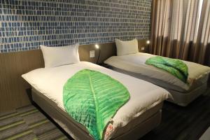 two beds in a hotel room withskirts at San Yuan Guest House in Jinning