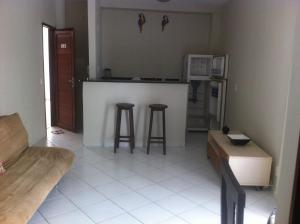 una cucina con bancone e 2 sgabelli da bar di Apto em Condomínio Brisas do Amor a Pipa