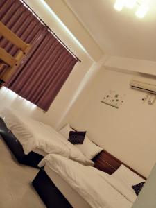 a bedroom with two beds and a window at Lu He Feng Homestay in Luodong
