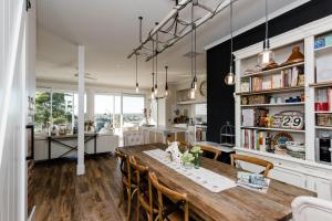 a kitchen and dining room with a wooden table and chairs at La Maison St Arnaud in Rutherglen