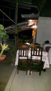 a table with two wooden chairs and a table with a tableablish at Hom Baan Chiang Mai in Chiang Mai
