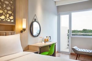 A bed or beds in a room at ibis Styles Cikarang