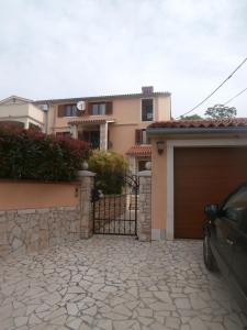 a house with a gate and a garage at Sea view apartmant Nona with pool in Ližnjan