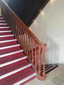 a wooden staircase with red and white carpet at Hotel Kumkum in Mumbai
