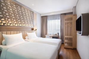 A bed or beds in a room at ibis Styles Cikarang