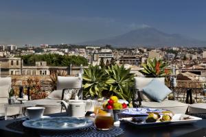 einen Tisch mit Essen drauf mit Blick auf die Stadt in der Unterkunft Palace Catania | UNA Esperienze in Catania