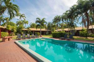 a swimming pool with a pool table and chairs at Bayside Holiday Apartments in Broome