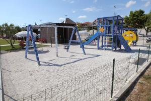 a playground with a swing set in the sand at Apartman Dinka in Trogir