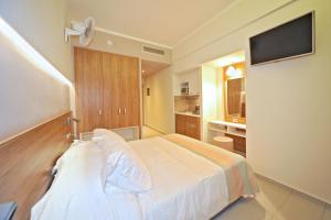 a hotel room with a bed and a television at Astron Suites & Apartments in Kos
