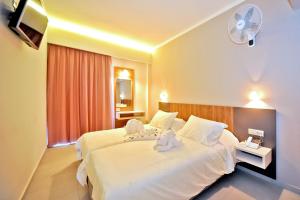 a hotel room with a bed with two stuffed animals on it at Astron Suites & Apartments in Kos