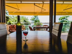 a glass of wine sitting on a wooden table at Villa Orka in Omišalj