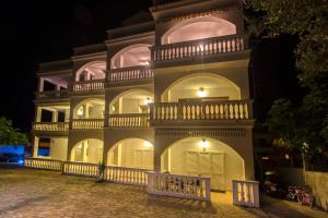 a large white building with a balcony at night at Apartmani Mariva in Vodice