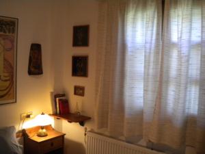 Zimmer mit einem Fenster mit weißen Vorhängen und einer Lampe in der Unterkunft Marelmy in Mouresi