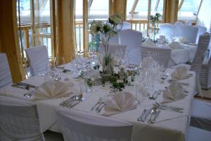 a group of tables with white chairs and silverware at Scheffer's Hotel in Altenmarkt im Pongau