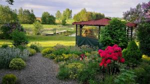 a garden with flowers and a gazebo at Agroturystyka Mazury Cicha Wólka in Zawady +16 photos